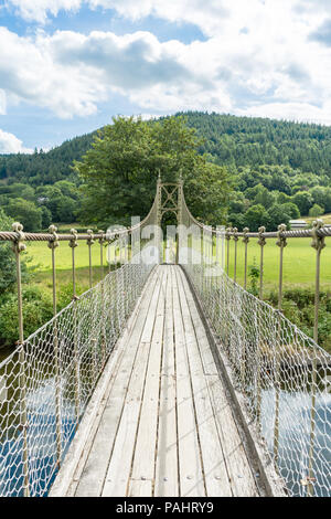 Rickety wooden footbridge over the River Conwy, with green trees, hills and water Stock Photo