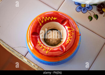 Colored empty ashtray on ceramic table Stock Photo