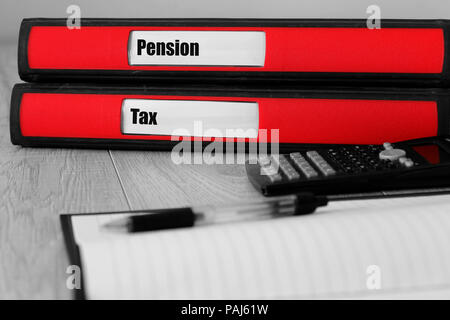 Red folders with pension and tax written on the label on a desk with selective colour Stock Photo