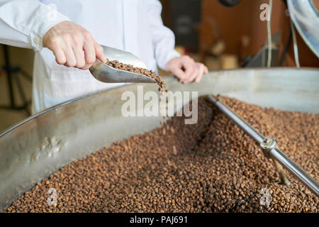 Worker Checking Roasting Process at Factory Stock Photo