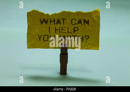 Text sign showing What Can I Help You With question. Conceptual photo Offering assistance Experts advice ideas Paperclip hold torn yellow page written Stock Photo