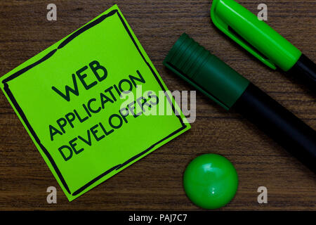 Text sign showing Web Application Developers. Conceptual photo Internet programming experts Technology software Written on sticky note two markers lai Stock Photo