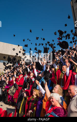 Higher Education in the UK: Students graduating from Aberystwyth university, throwing their caps and mortar boards in the air for their traditional graduation photograph. July 2018 Stock Photo