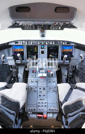 seats, control-yokes and instruments in the cockpit of an Ocean Sky Aviation Bombardier Challenger 605 Stock Photo