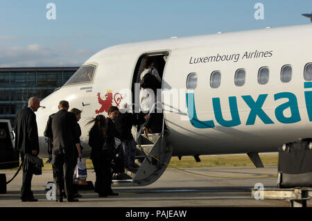 passengers with carry-on bags boarding a Luxair Bombardier DHC-8 Dash 8-400 Q400 parked at London City Stock Photo