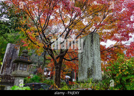 Kyoto, Japan - Nov 19, 2016. Stone monument with autumn trees on Philosopher Path at rainy day in Kyoto, Japan. Stock Photo