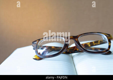 close up vintage glasses on blurred opened book with copy space Stock Photo