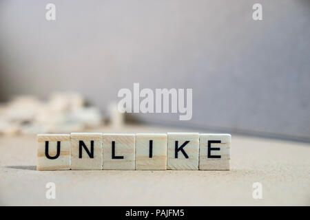 unlike word written on wood block Stock Photo