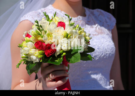 Bride holding colorful flowers bouquet with her hands on wedding day Stock Photo