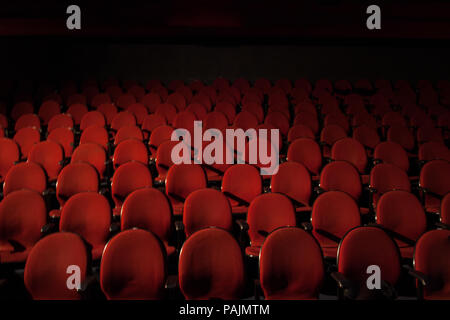 Red theatre seats with black dark shadow on the background. Stock Photo