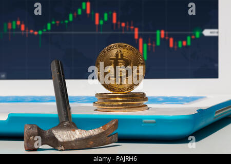 Golden Bitcoin virtual currency on laptop with hammer. Close-up of front side. Virtual cryptocurrency concept. Stock Photo