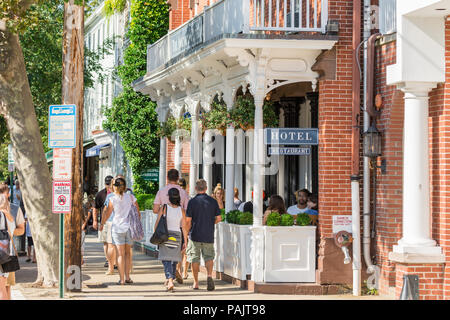 groups of people walking on the sidewalk in front of the American Hotel in Sag Harbor, NY Stock Photo