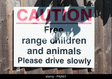 An amusing sign warning drivers of the presence of children and animals Stock Photo