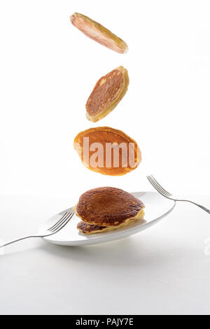 Flying stack of pancakes with blueberry, blackberry and raspberry isolated on white background Stock Photo