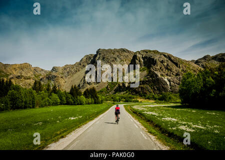Female cyclist cycling on Leka Island, Norway Stock Photo