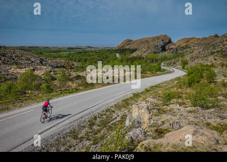 Female cyclist cycling on Leka Island, Norway Stock Photo