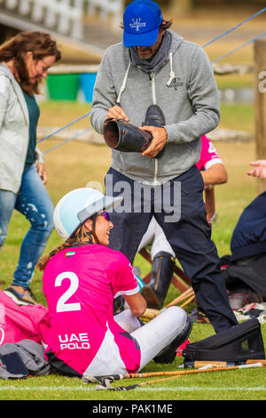 Polo legend Adolfo Cambiaso assists his 16 year old daughter Mia of the UAE Ladies Polo Team with her boots after their victory over Maiz Dulce in the Stock Photo