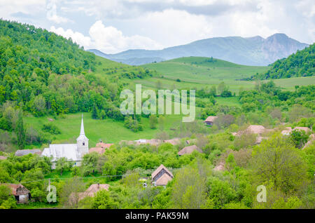 Old Transylvanian village in a natural area with trees, forests, hills and mountains in this well preserved rural countryside area Stock Photo