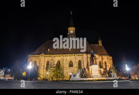 Gothic Cathedral church in the center of Cluj-Napoca in Transylvania Region of Romania with the Unirii Square and Matei Corvin statue during the night Stock Photo