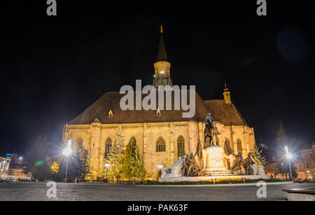 Gothic Cathedral church in the center of Cluj-Napoca in Transylvania Region of Romania with the Unirii Square and Matei Corvin statue during the night Stock Photo