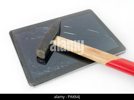 Hammer on a tablet with a cracked broken touchscreen glass suggesting the need for repair and service under warranty Stock Photo