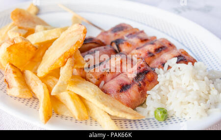 Grilled chicken souvlaki rolls with french fried potatoes and boiled rice on a white plate Stock Photo