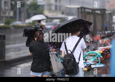 Chengdu,Sichuan,China,24th July,2018.Heavy rain has suddenly disrupted pedestrians in Chengdu, Southwest China's Sichuan Province.  The sunny weather continues until the 4 p.m., when thunderstorms are unexpected. Sichuan has been battered by heavy rain this summer. Meteorological authorities have warned the public to be prepared for potential disasters as the rain continues.Credit:Costfoto/Alamy Live News Stock Photo