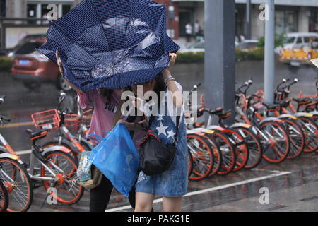 Chengdu,Sichuan,China,24th July,2018.Heavy rain has suddenly disrupted pedestrians in Chengdu, Southwest China's Sichuan Province.  The sunny weather continues until the 4 p.m., when thunderstorms are unexpected. Sichuan has been battered by heavy rain this summer. Meteorological authorities have warned the public to be prepared for potential disasters as the rain continues.Credit:Costfoto/Alamy Live News Stock Photo