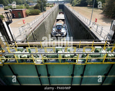 Friedrichsfeld, Germany. 24th July, 2018. A cargo ship stands in the Friedrichsfeld lock near Wesel. The lock dams the Wesel-Datteln Canal just before the mouth of the Rhine. Due to fragile bollards on the lock walls, there are long waiting times at the locks. Credit: Roland Weihrauch/dpa/Alamy Live News Stock Photo