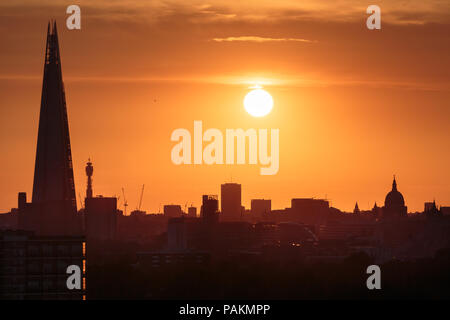 London, UK. 24th July, 2018. UK Weather: Setting sun over the city landscape with The Shard Skyscraper and St. Paul’s Cathedral. Credit: Guy Corbishley/Alamy Live News Stock Photo