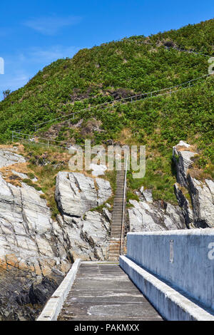 Steps leading up the cliff face from the outer harbour wall at Laxey, Isle of Man Stock Photo