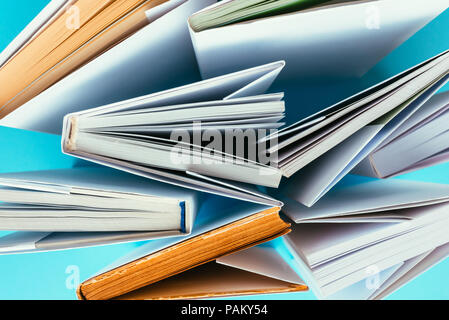 Books from above on blue background, education and literacy concept Stock Photo