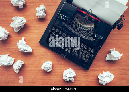 Writer's block concept with typewriter and crumpled paper on work desk Stock Photo