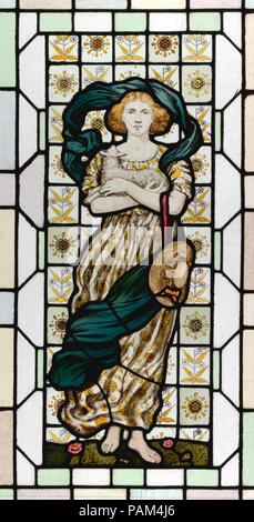 Spring. Culture: American. Dimensions: 52 5/8 × 30 in. (133.7 × 76.2 cm). Maker: Daniel Cottier & Company. Date: ca. 1873-85.  The Aesthetic movement witnessed a revival of stained glass, primarily in the languid figural style associated with the English Pre-Raphaelites. The stained-glass artist Daniel Cottier was an important conduit for introducing this style to American audiences, and his New York studios, which opened in 1873, produced and marketed art furniture, upholstery, stained glass, and other decorative arts. In this allegory of Spring--from a series of the four seasons--a young wom Stock Photo