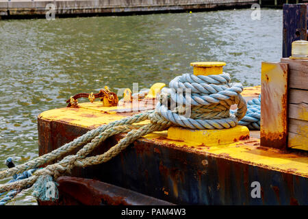 A mooring bollard entwined with a mooring rope port Stock Photo