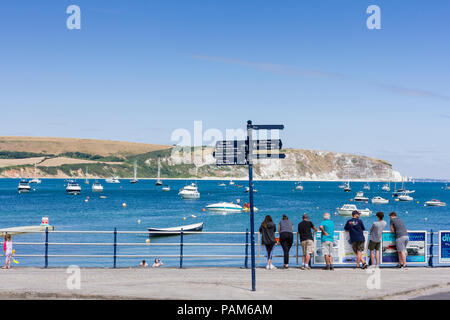 People on Swanage promenade looking out to sea on a warm sunny summers day during the heatwave of 2018, Dorset, United Kingdom Stock Photo