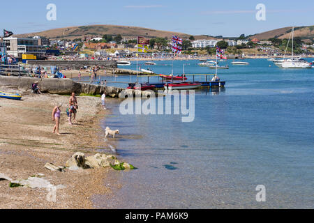 People enjoying a lovely Sunday afternoon beside the sea  during the UK heatwave of 2018, Swanage, Dorset, United Kingdom