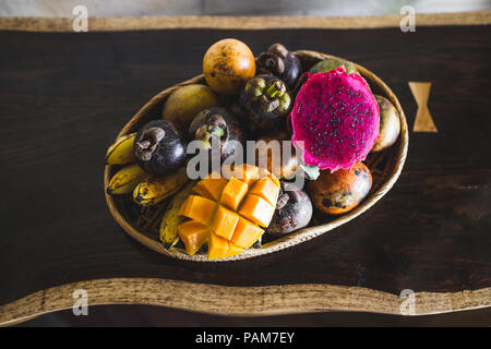 Fruit plate with mango, passion fruit, mangosteen, dragonfruit on wooden table Stock Photo