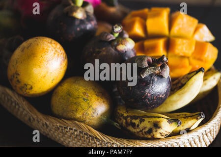 Fruit plate with mango, passion fruit, mangosteen, dragonfruit on wooden table Stock Photo