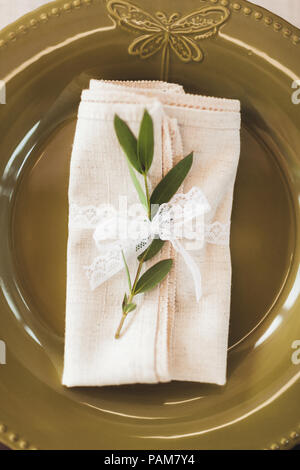 Green decorated cutlery with plant leaves and white napkins on wedding table. Rustic style Stock Photo