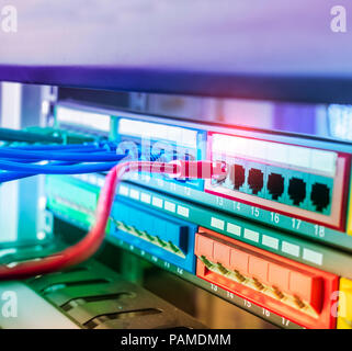 row of network cables are connected to a switch Stock Photo