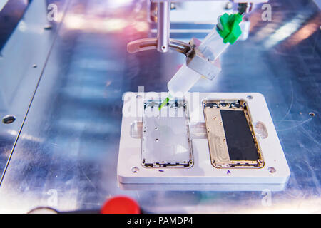 technology of nozzle device and needle of automatic glue dispenser machine (glue injection) at mobile phone factory Stock Photo