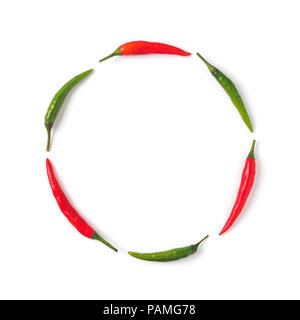 Creative layout chilli peppers. Circle form made from green and red hot pepper, isolated on white. Copy space for text. Top view or flat-lay. Stock Photo