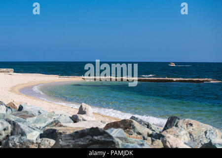 Fantastic views of rocky coast and  beautiful sandy beach on a sunny day with blue sky. Picturesque and gorgeous scene.Beautiful beach in Ouranoupolis Stock Photo