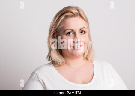 Portrait of an attractive overweight woman in studio on a white background. Stock Photo