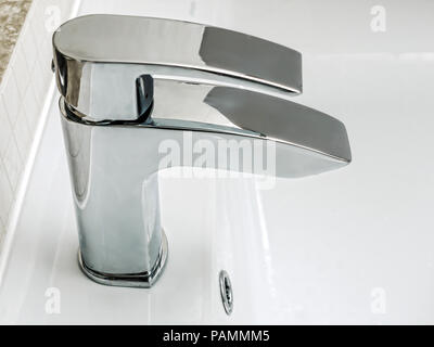 Bathroom chrome faucet of white ceramic washbasin Stock Photo