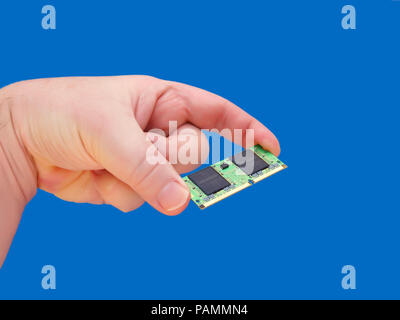 Hand holding RAM memory for laptops-Blue Background Stock Photo