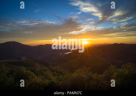 Landscape of beautiful orange and blue sunset over the Sierra foothills, taken  from Priest Grade Road, Groveland Stock Photo