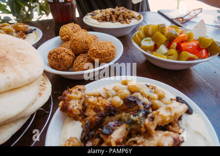 bowls of fresh falafel and hummus sit on a table in Jerusalem, Israel Stock Photo