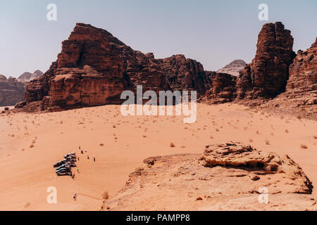 jeeps carrying tourists park near a vantage point near the Seven Pillars in the Wadi Rum desert, Jordan Stock Photo